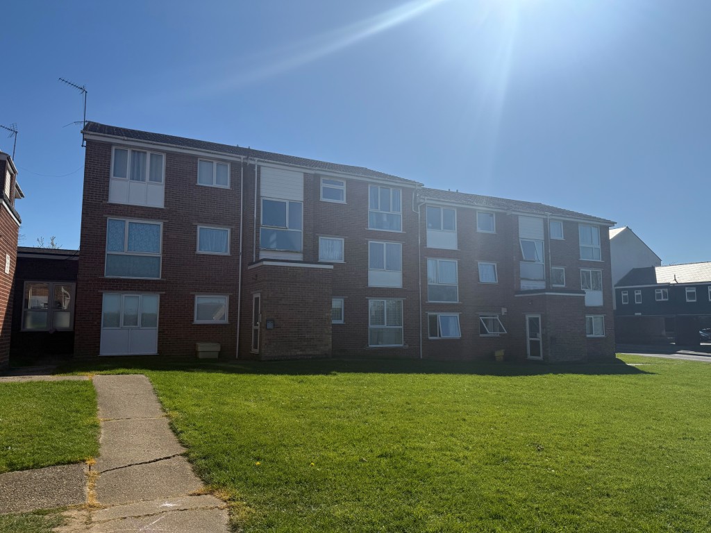 Lot: 116 - TWO-BEDROOM GROUND FLOOR APARTMENT CLOSE TO BRAINTREE TOWN CENTRE - Shot showing front of building and grass communal area